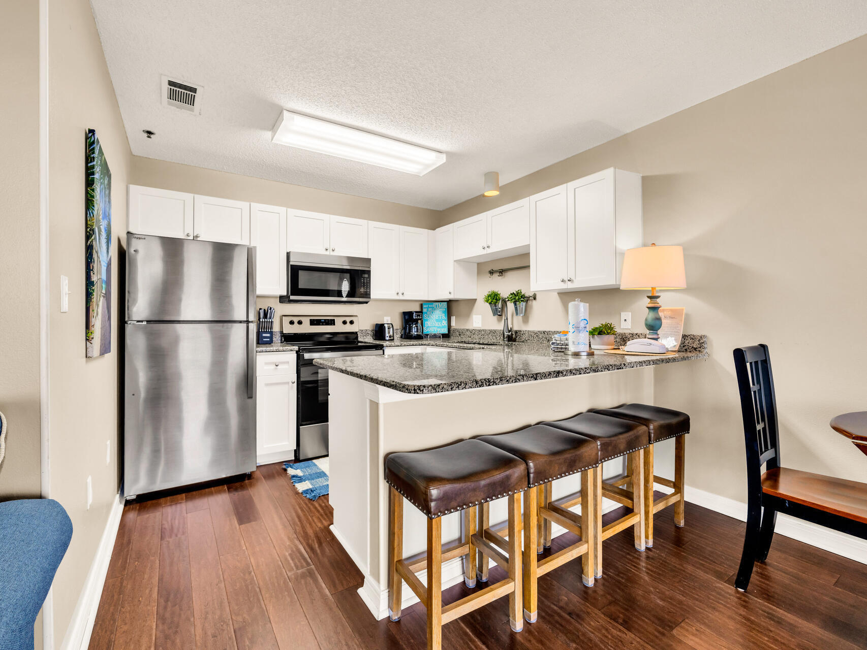 144 Spires Lane, Unit 410 Santa Rosa Beach, FL 32459 - Photo 15 of 33 a kitchen with stainless steel appliances a refrigerator a stove a sink dishwasher and a dining table with wooden floor