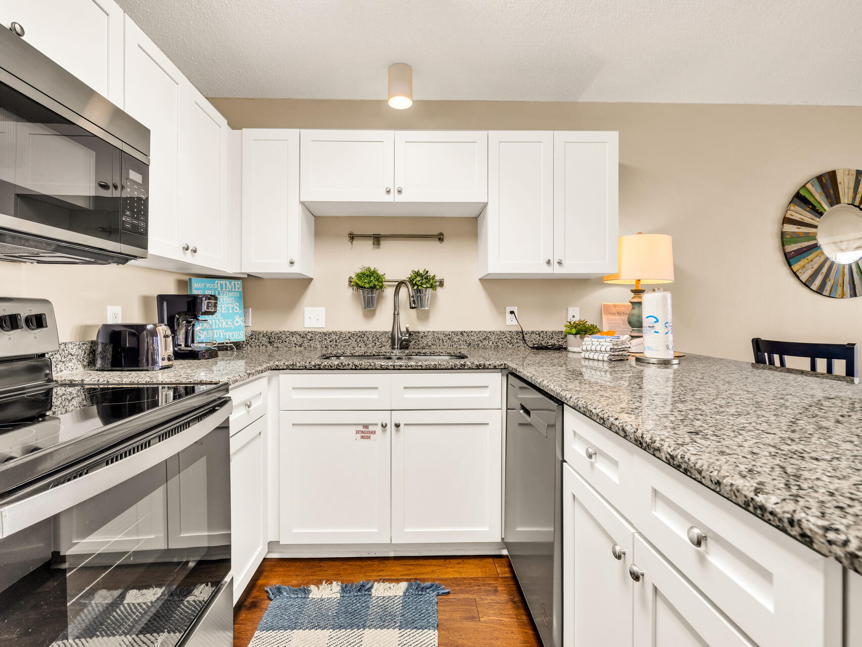 144 Spires Lane, Unit 410 Santa Rosa Beach, FL 32459 - Photo 16 of 33 a kitchen with granite countertop a sink stainless steel appliances and white cabinets