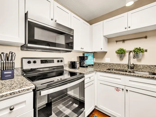 a kitchen with granite countertop a stove microwave and cabinets