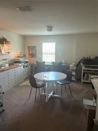 a kitchen with a dining table chairs and a refrigerator