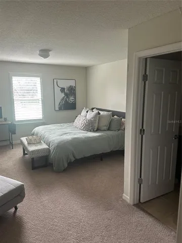 a bedroom with bed couch and window