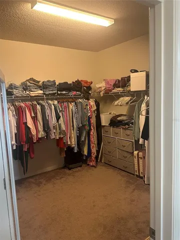 a view of walk in closet with clothes