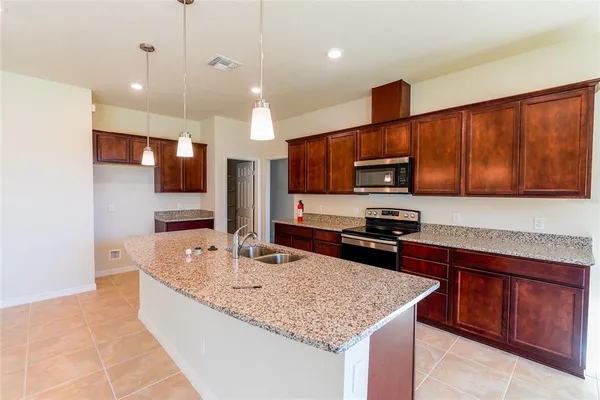 a kitchen with stainless steel appliances granite countertop a sink refrigerator and microwave