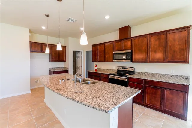 a kitchen with stainless steel appliances granite countertop a sink refrigerator and microwave