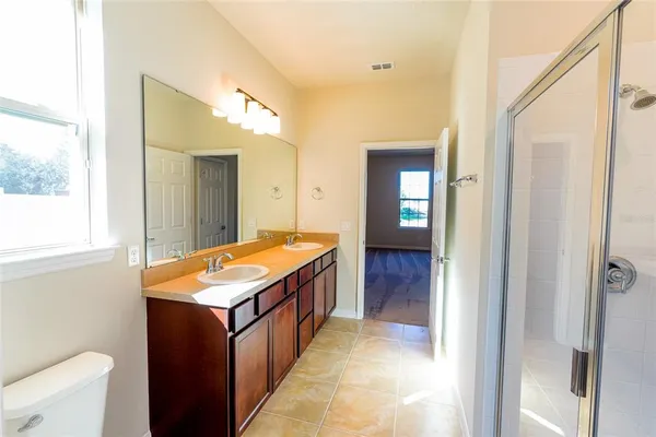 a en suite bathroom with a granite countertop sink and a mirror