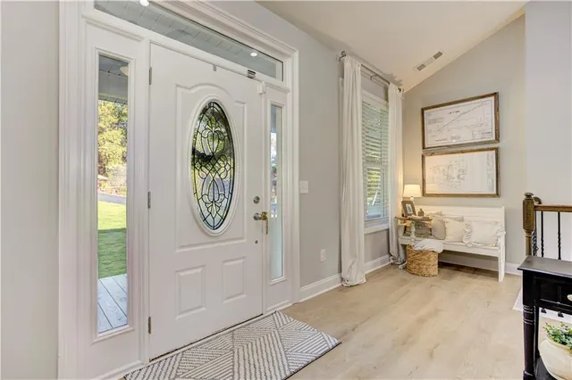 a dining room with stainless steel appliances furniture a chandelier and kitchen view