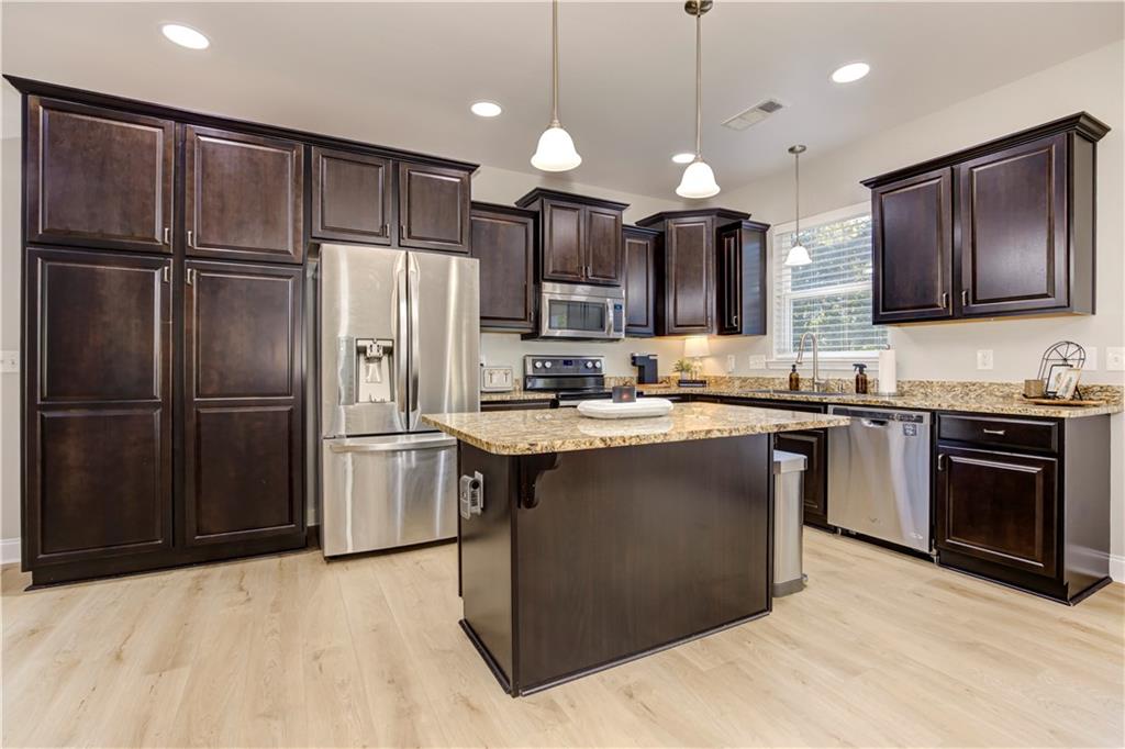 304 Garland Way Canton, GA 30115 - Photo 29 of 138 a kitchen with kitchen island granite countertop stainless steel appliances and wooden cabinets