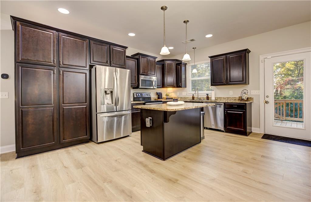 304 Garland Way Canton, GA 30115 - Photo 30 of 138 a kitchen with stainless steel appliances granite countertop a stove top oven a sink dishwasher a refrigerator and a refrigerator with wooden floor