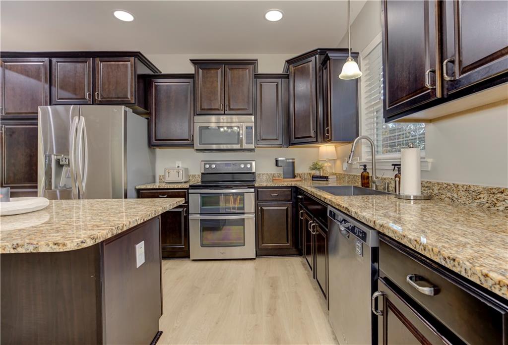 304 Garland Way Canton, GA 30115 - Photo 32 of 138 a kitchen with stainless steel appliances granite countertop a sink stove and refrigerator