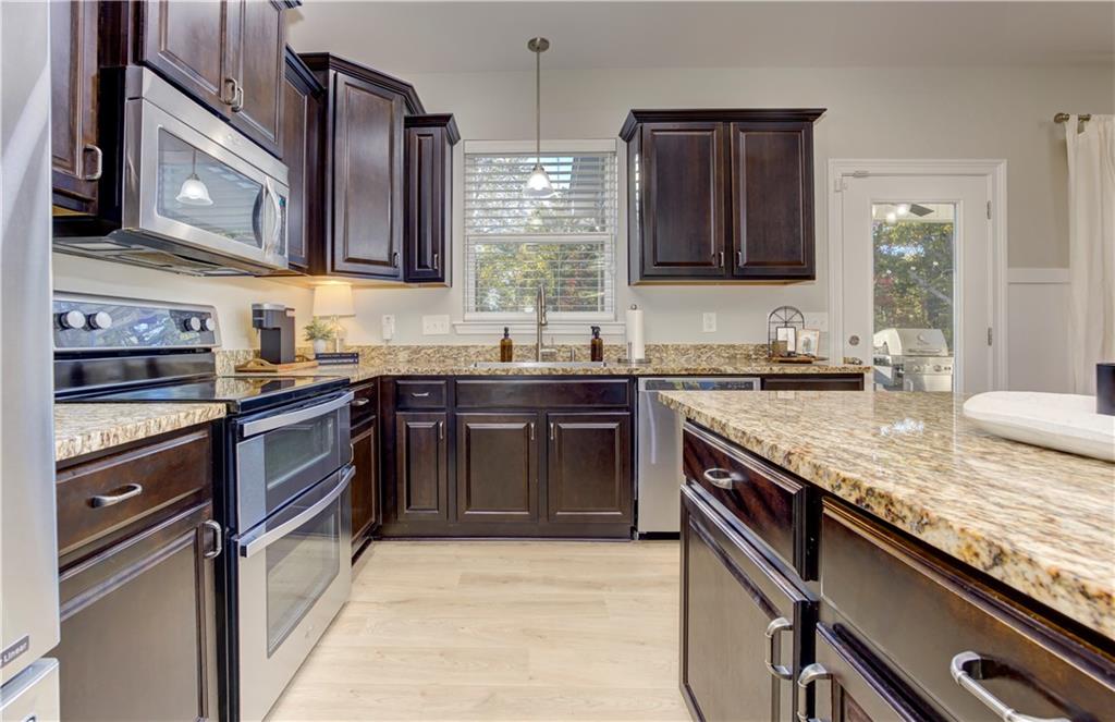 304 Garland Way Canton, GA 30115 - Photo 33 of 138 a kitchen with stainless steel appliances granite countertop a sink stove and cabinets