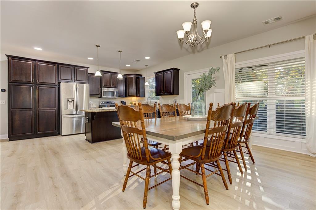 304 Garland Way Canton, GA 30115 - Photo 39 of 138 a dining room with stainless steel appliances kitchen island granite countertop a dining table chairs and a refrigerator