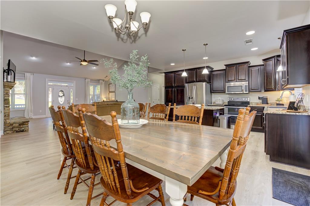 304 Garland Way Canton, GA 30115 - Photo 41 of 138 a dining room with stainless steel appliances furniture a chandelier and kitchen view