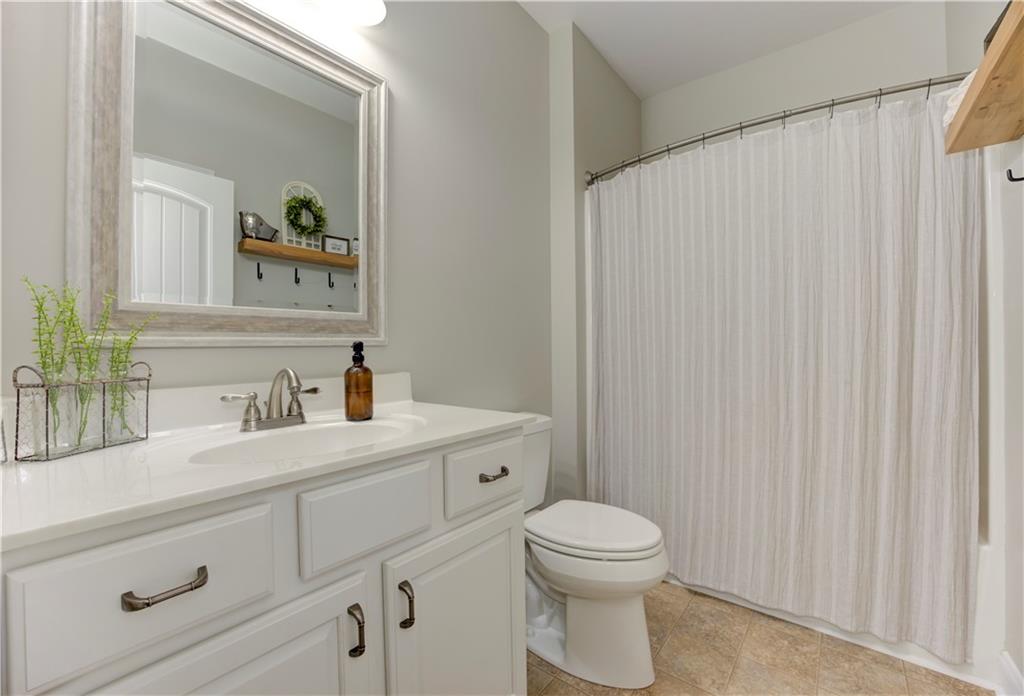 304 Garland Way Canton, GA 30115 - Photo 54 of 138 a bathroom with a toilet a sink a vanity and mirror