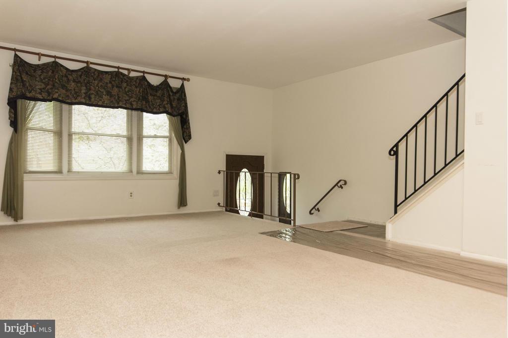 919 Elm Road Baltimore, MD 21227 - Photo 3 of 18 a view of an empty room with wooden floor and a window