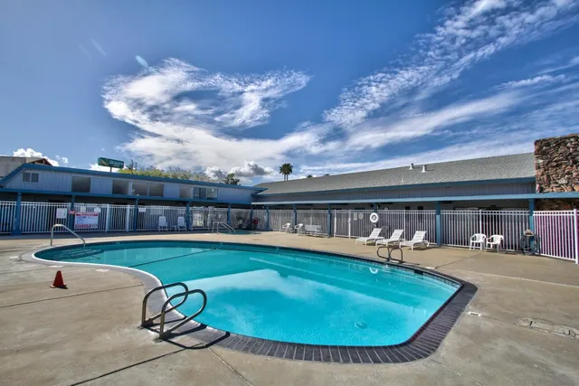 a swimming pool with outdoor seating and yard