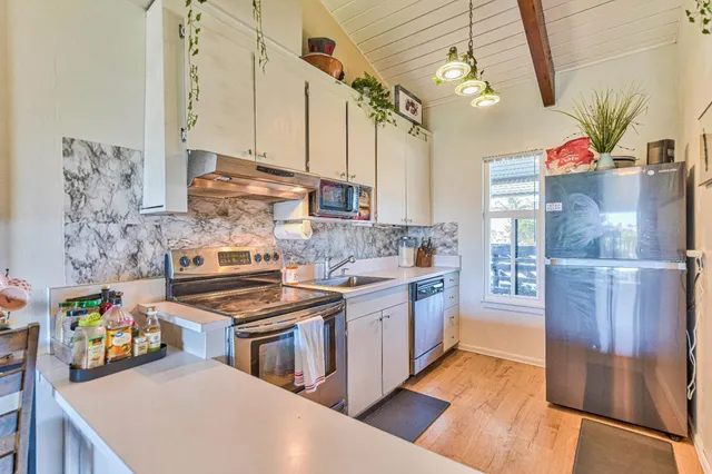 a kitchen with stainless steel appliances a stove and cabinets