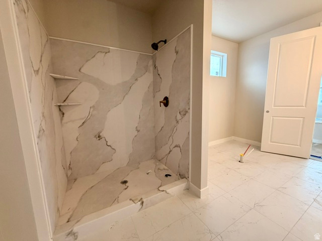 5885 Canyon Rim Road, Unit 624 Lehi, UT 84048 - Photo 7 of 10 Walk-in shower featuring marble-look paneling, integrated shelving, and bronze fixtures