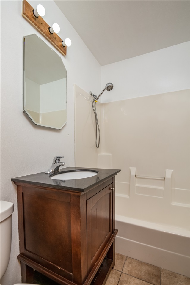 7712 Randy Road Machesney Park, IL 61115 - Photo 12 of 25 a bathroom with a sink a toilet and a mirror