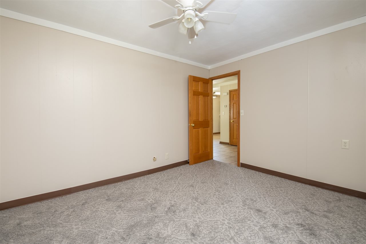 7712 Randy Road Machesney Park, IL 61115 - Photo 17 of 25 an empty room with a ceiling fan and a window