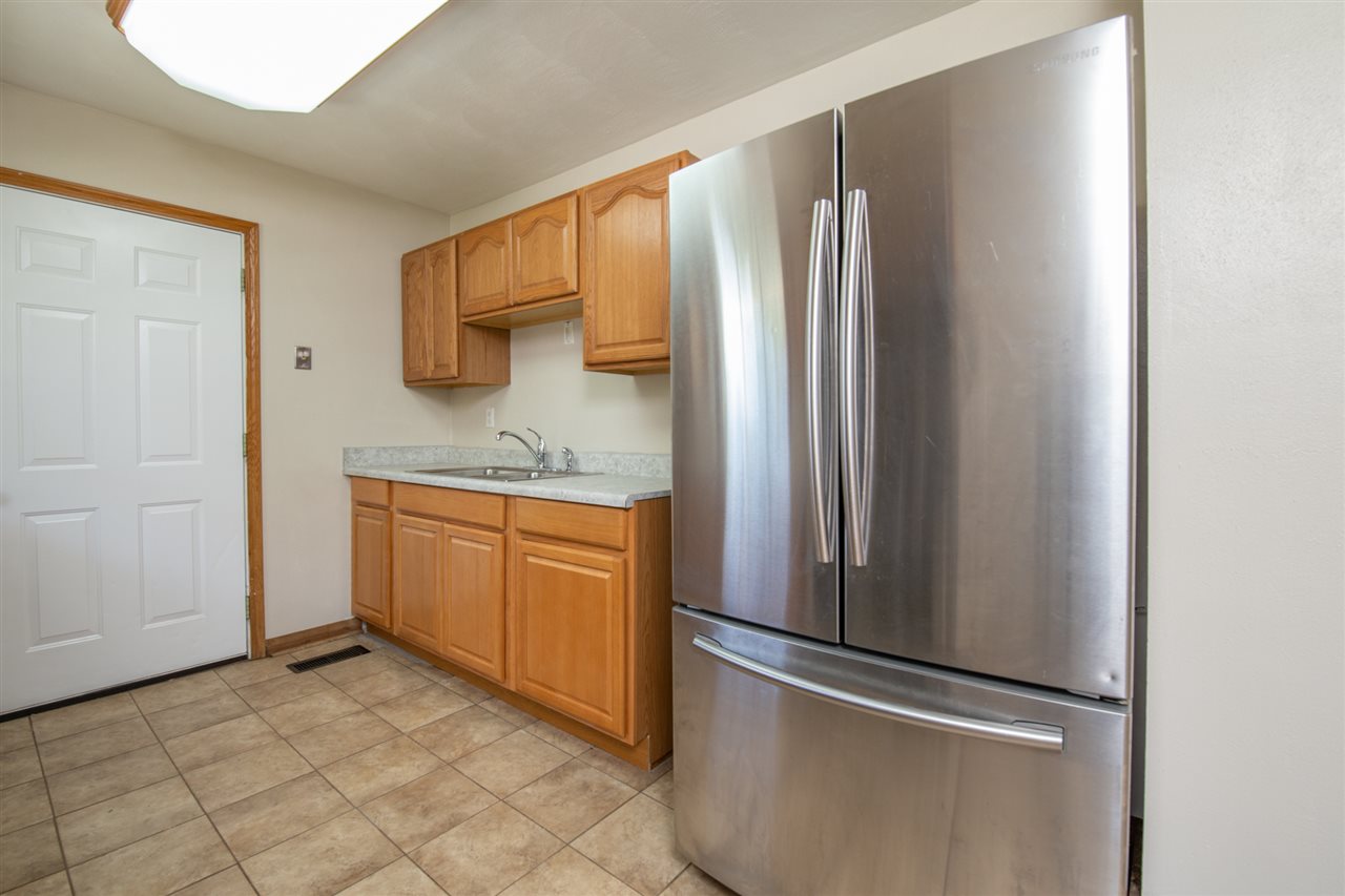 7712 Randy Road Machesney Park, IL 61115 - Photo 7 of 25 a kitchen with stainless steel appliances granite countertop a refrigerator and a sink