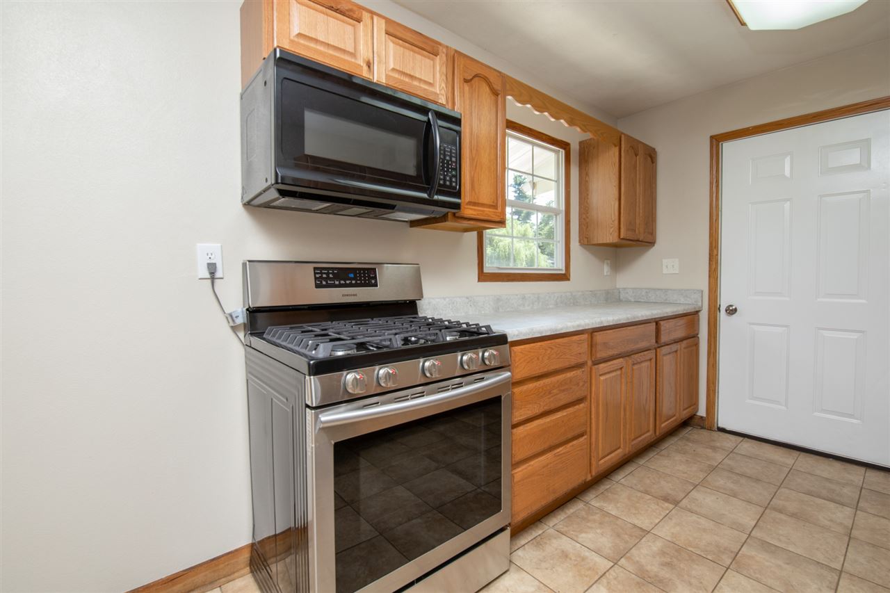 7712 Randy Road Machesney Park, IL 61115 - Photo 8 of 25 a kitchen with granite countertop cabinets stainless steel appliances and a window
