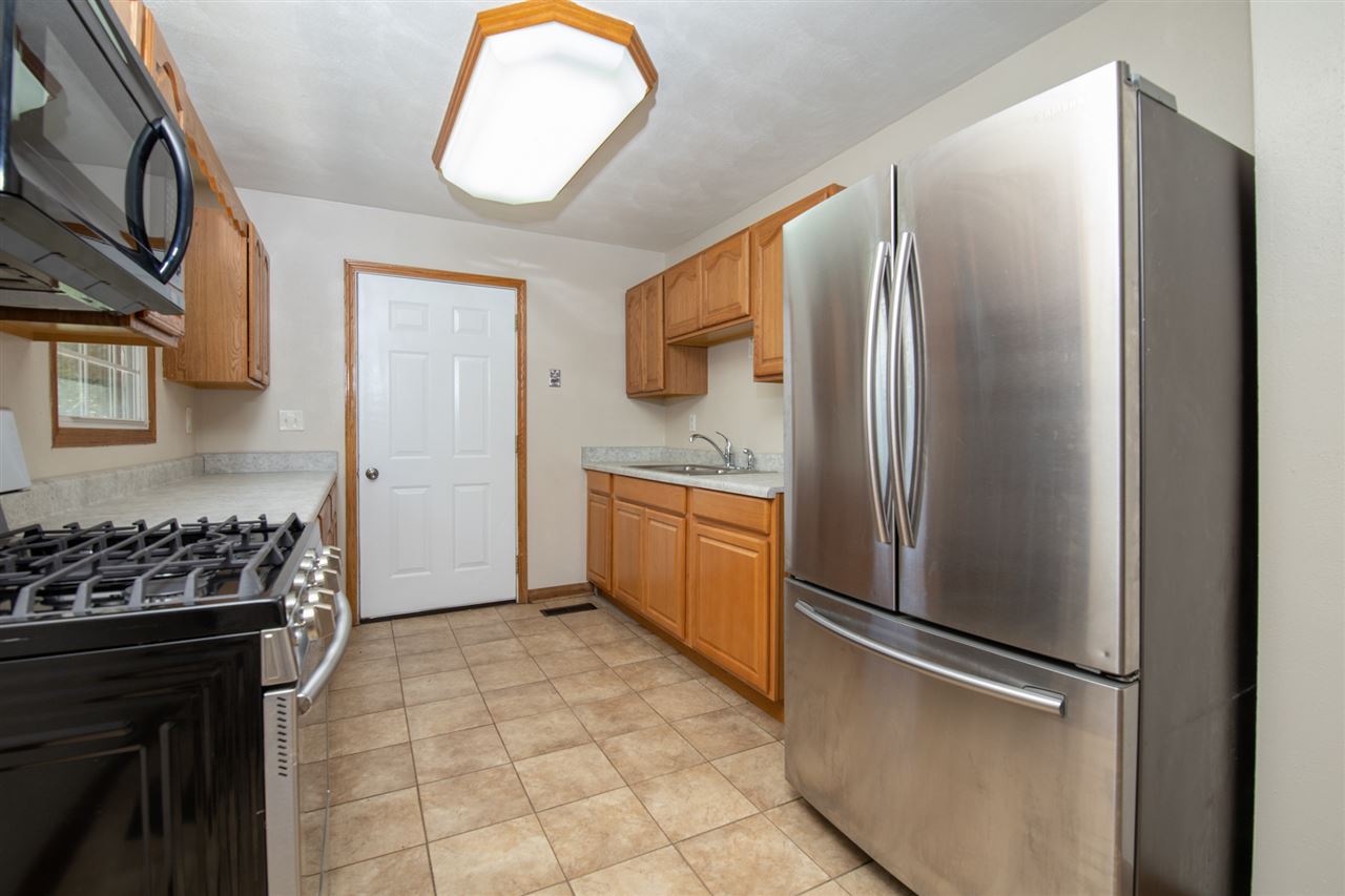 7712 Randy Road Machesney Park, IL 61115 - Photo 9 of 25 a kitchen with stainless steel appliances granite countertop a refrigerator and a stove