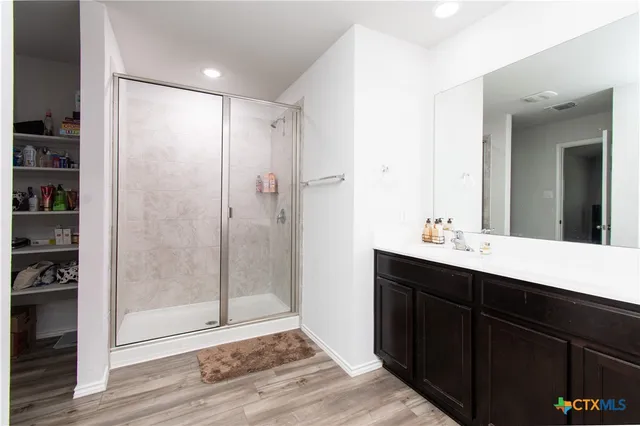 a bathroom with a shower sink and mirror