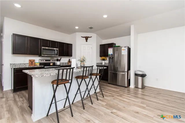a kitchen with stainless steel appliances a refrigerator stove microwave and cabinets