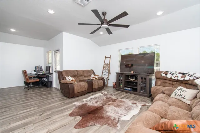 a living room with furniture and a flat screen tv with wooden floor