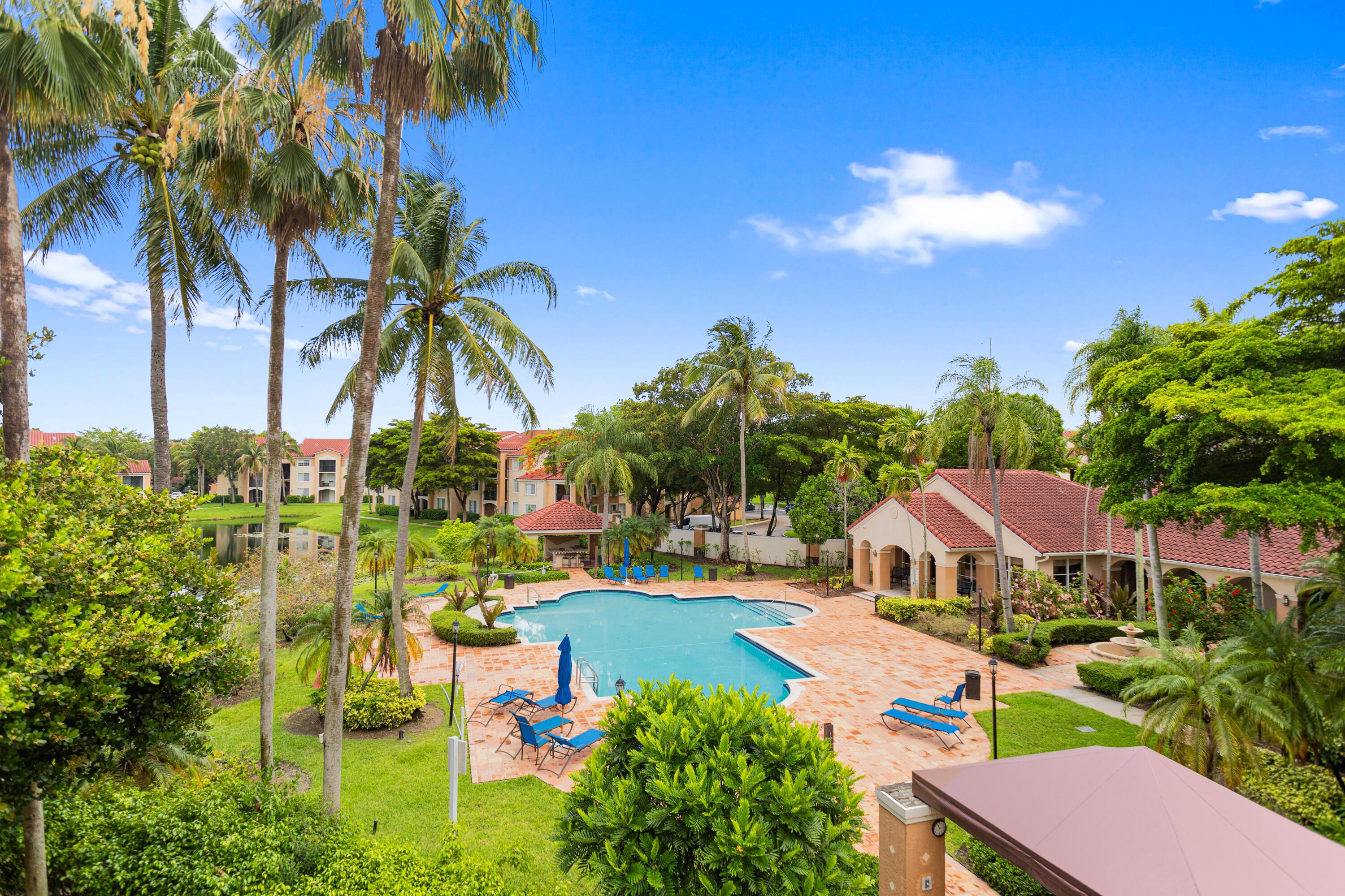 2113 Renaissance Boulevard, Unit 306 Miramar, FL 33025 - Photo 36 of 59 a view of swimming pool with a table and chairs under an umbrella