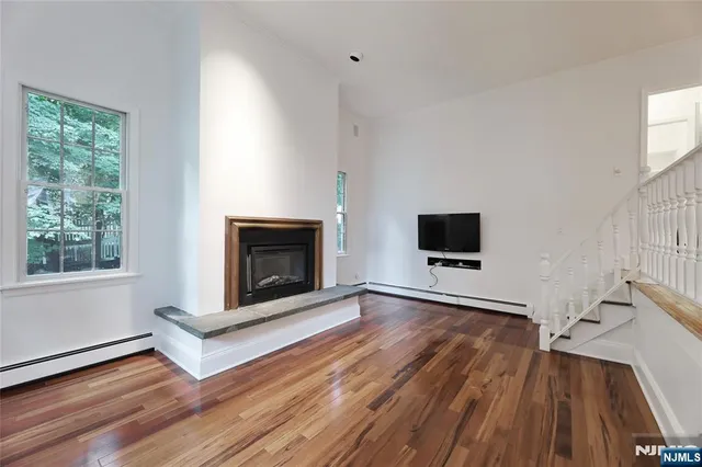 a living room with wooden floor and a fireplace