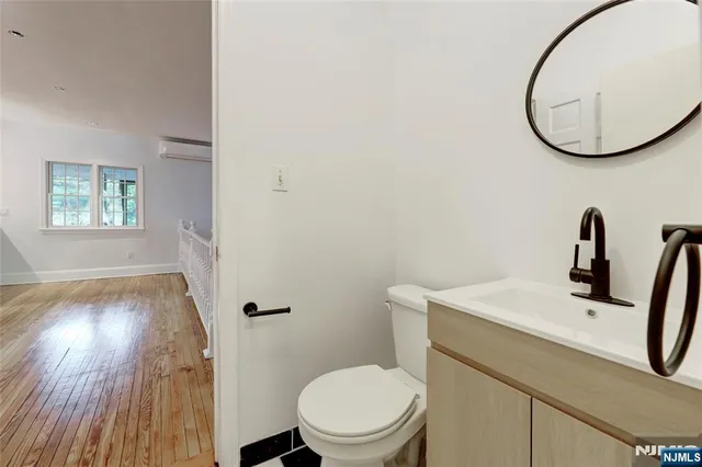a bathroom with a toilet a sink and a mirror