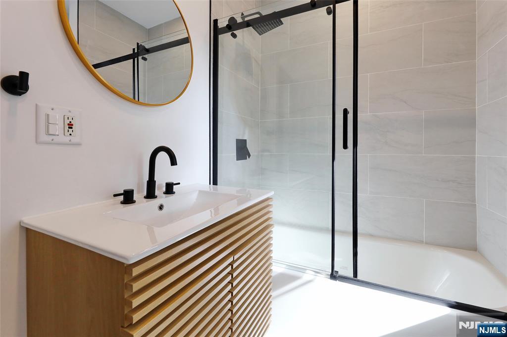24 Merrifield Way Cresskill, NJ 07626 - Photo 22 of 27 a bathroom with a sink a mirror and a shower