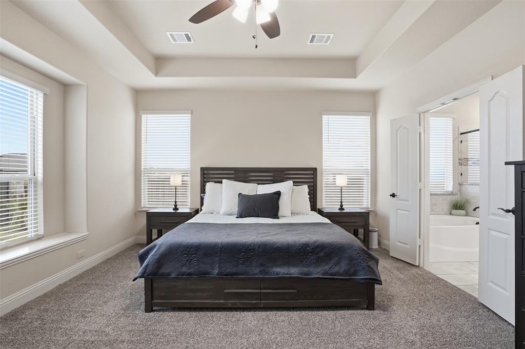 4002 Grove Valley Road Midlothian, TX 76065 - Photo 17 of 40 a bedroom with a large bed and a chandelier