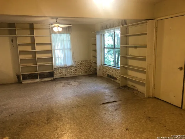 a view of a dry yard with wooden fence