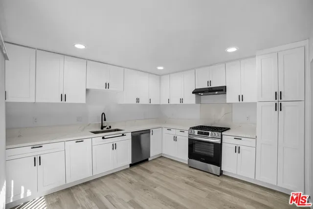 a kitchen with stainless steel appliances granite countertop a sink and cabinets