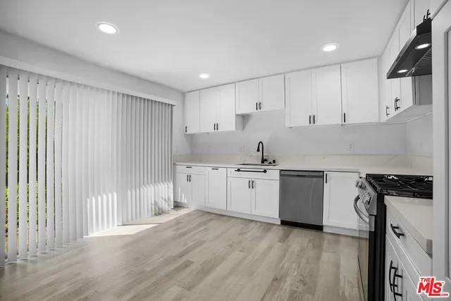 a kitchen with granite countertop white cabinets and white appliances
