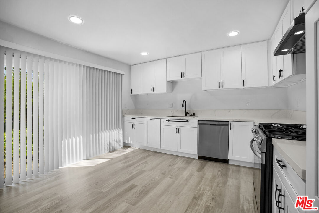 963 Glencliff Street La Habra, CA 90631 - Photo 12 of 31 a kitchen with granite countertop white cabinets and white appliances