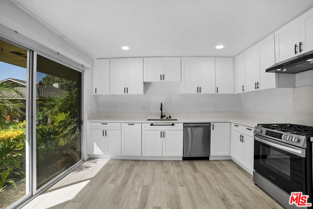 963 Glencliff Street La Habra, CA 90631 - Photo 13 of 31 a kitchen with stainless steel appliances granite countertop a stove a sink and a refrigerator