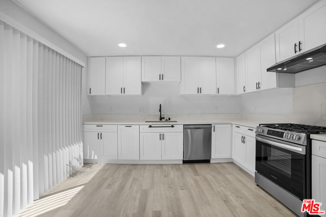 963 Glencliff Street La Habra, CA 90631 - Photo 14 of 31 a kitchen with stainless steel appliances granite countertop a stove a sink and white cabinets