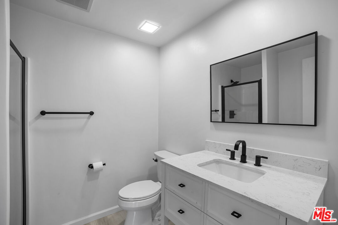 963 Glencliff Street La Habra, CA 90631 - Photo 19 of 31 a bathroom with a toilet a sink a mirror and vanity