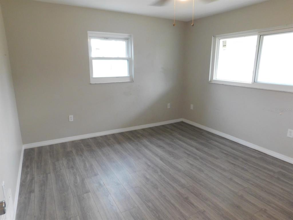 4721 Pompano Road Venice, FL 34293 - Photo 2 of 13 an empty room with wooden floor and windows