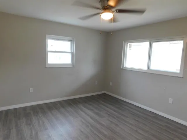 an empty room with a window and wooden floor