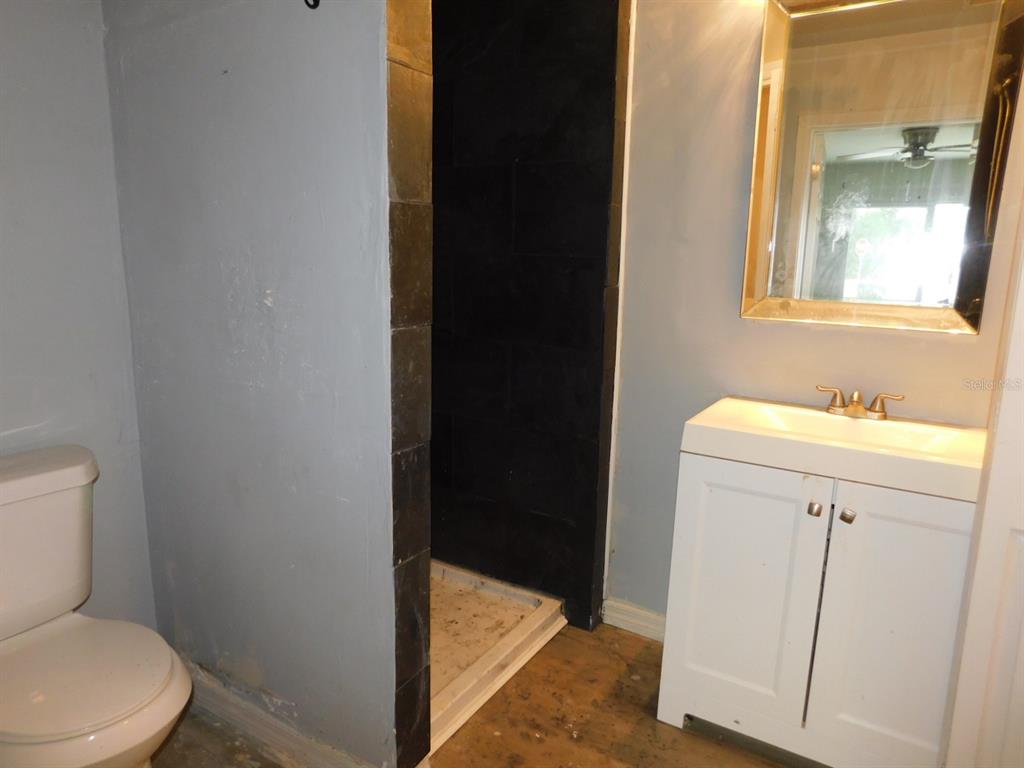 4721 Pompano Road Venice, FL 34293 - Photo 7 of 13 a bathroom with a sink a toilet a vanity and mirror