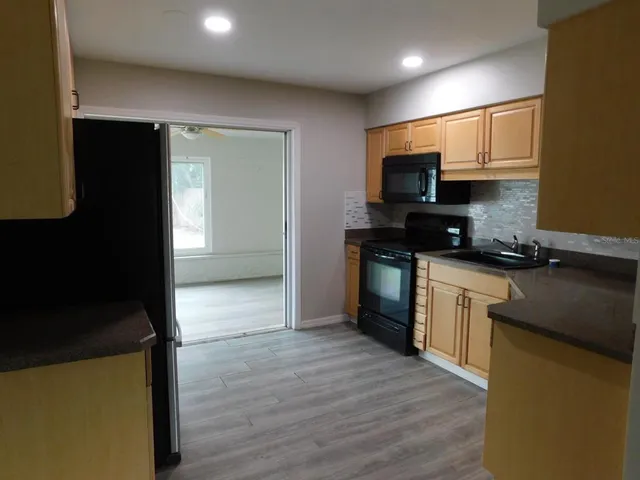 a kitchen with stainless steel appliances granite countertop a stove a sink and a refrigerator