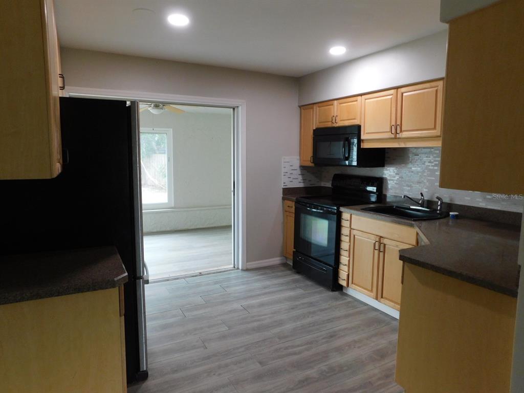 4721 Pompano Road Venice, FL 34293 - Photo 9 of 13 a kitchen with stainless steel appliances granite countertop a stove a sink and a refrigerator