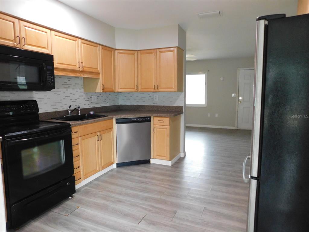 4721 Pompano Road Venice, FL 34293 - Photo 10 of 13 a kitchen with stainless steel appliances granite countertop a stove a sink and a microwave
