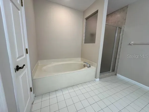 a spacious bathroom with a bathtub and shower
