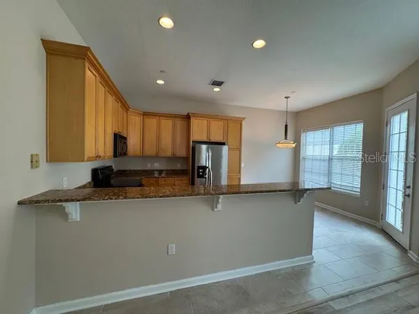 a kitchen with stainless steel appliances granite countertop a sink a stove and a refrigerator