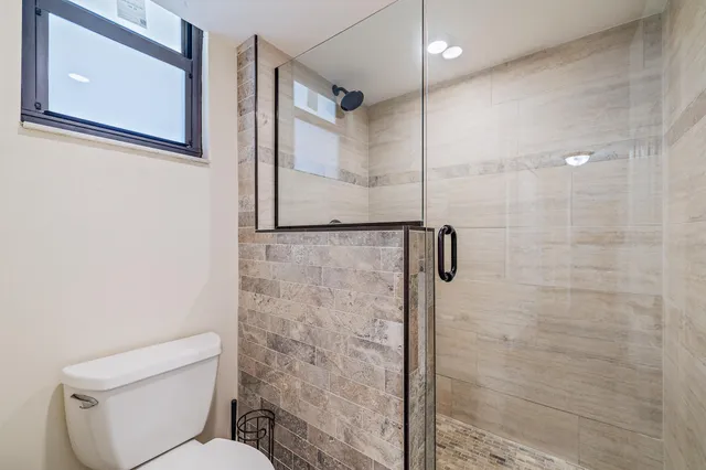 a bathroom with a toilet and a shower